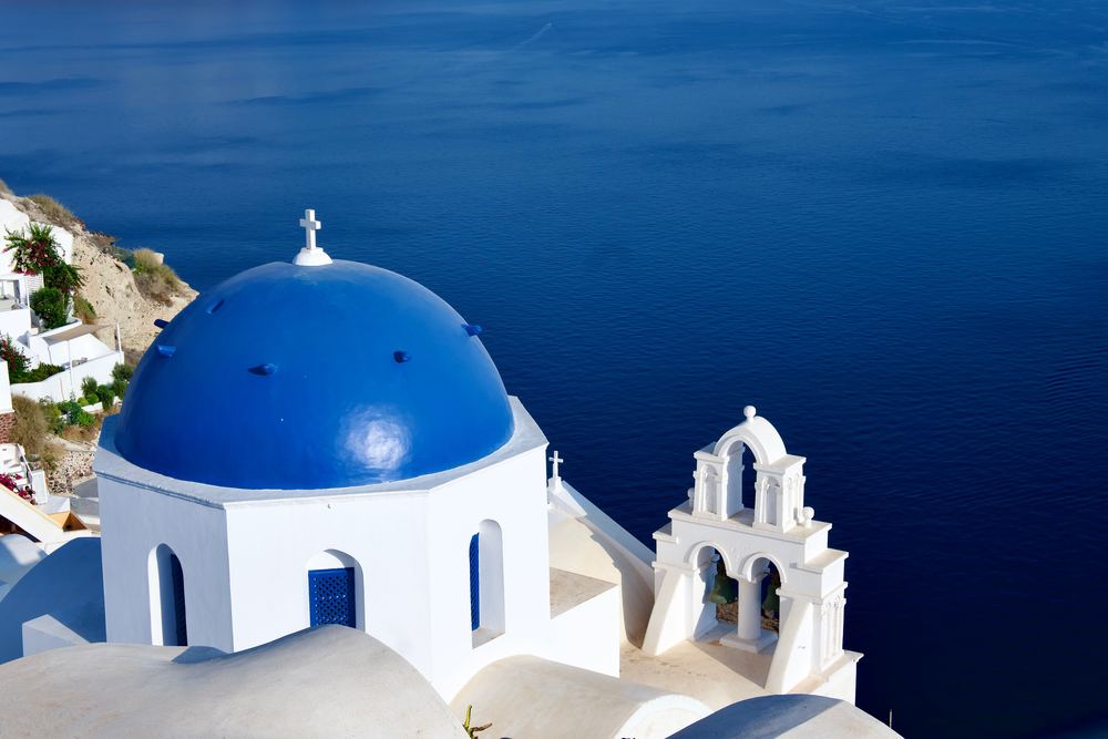 Blue-domed church on Santorini above the Aegean