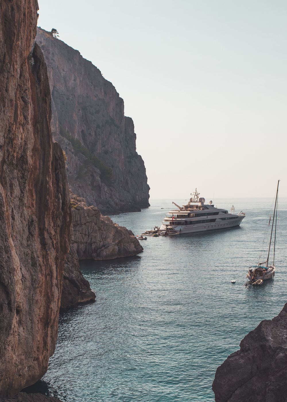 A large motor yacht at anchor in a rocky cove on Mallorca