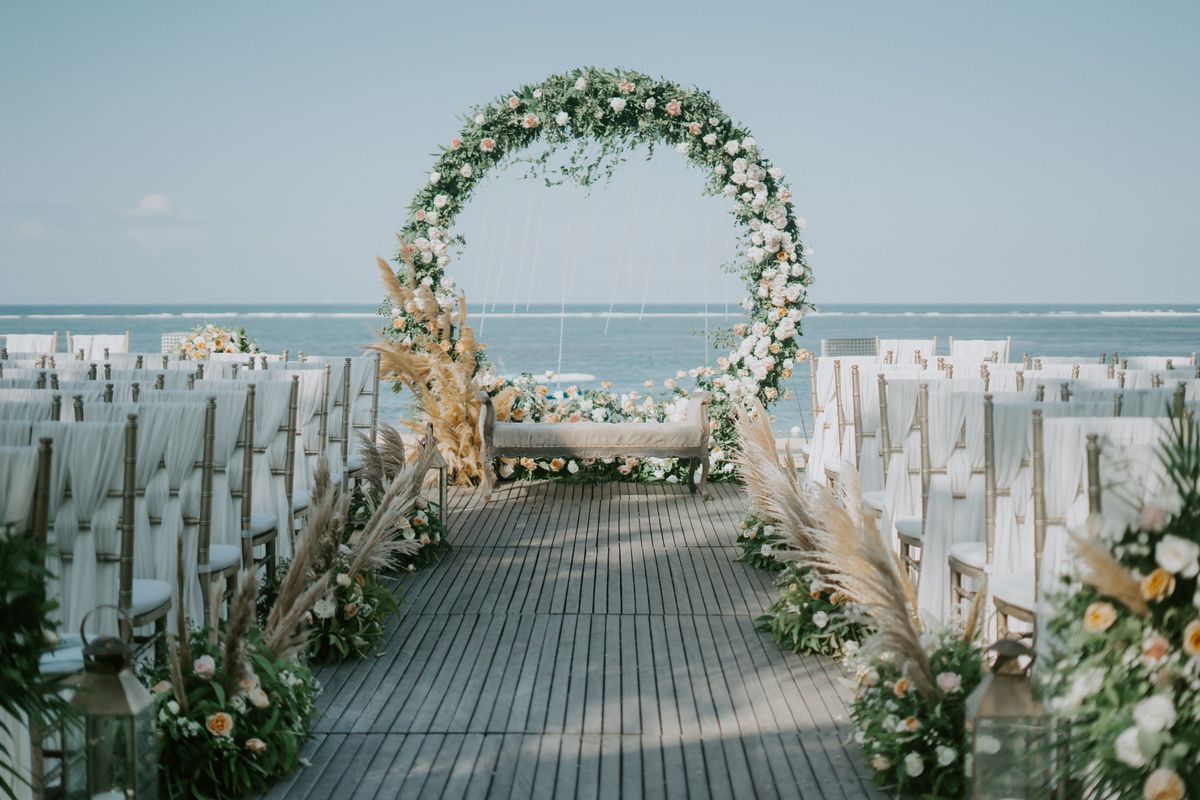 Flower arch for a wedding ceremony on the beach, the sea behind