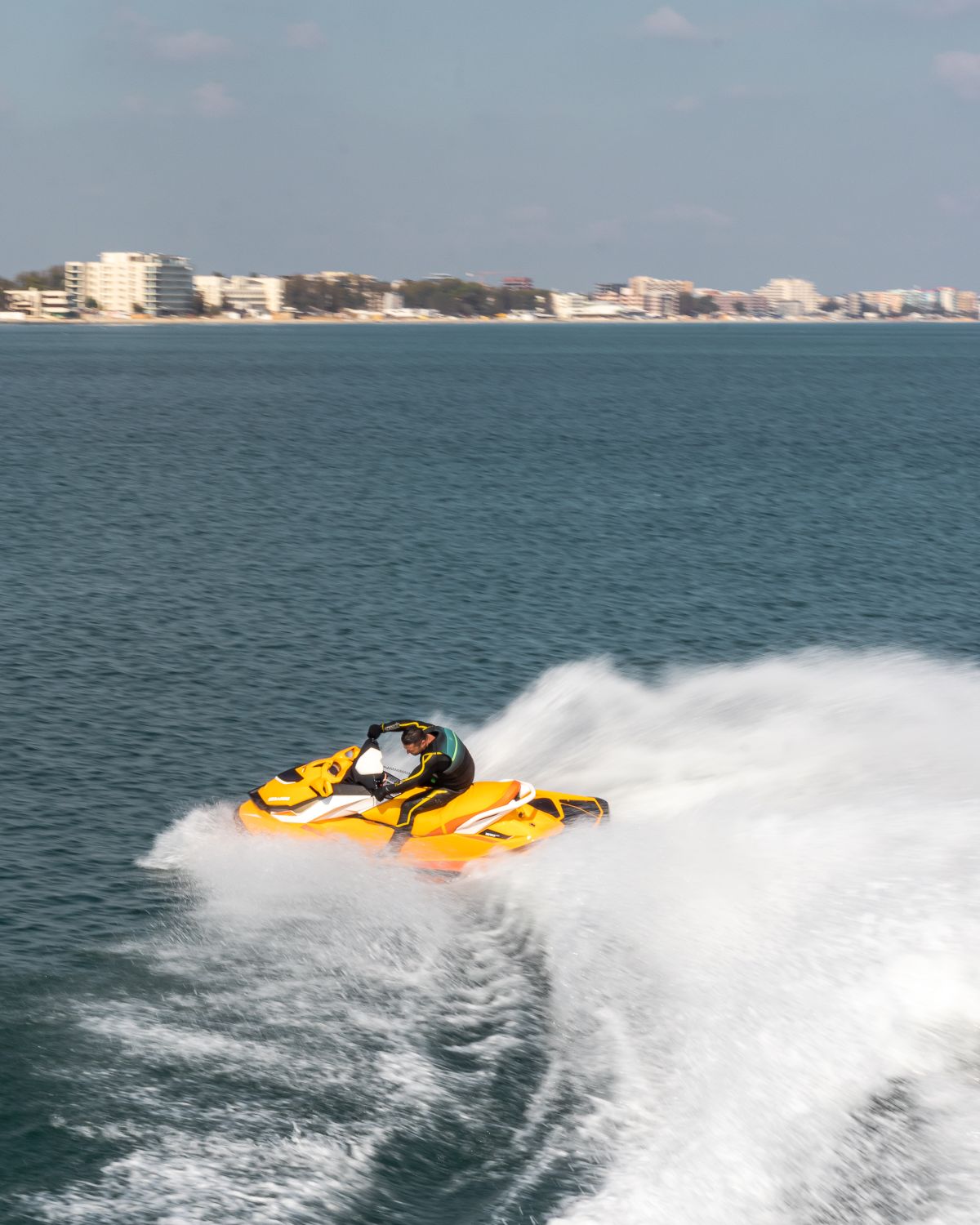 Jet ski at full speed with spray on turquoise water